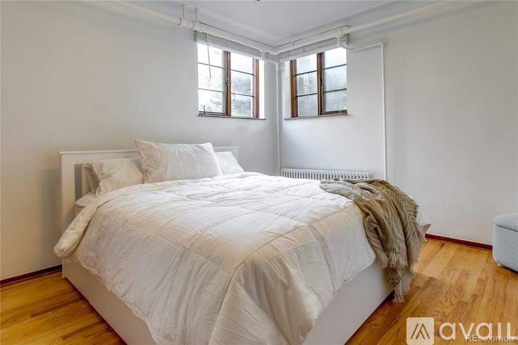 A bedroom with a large bed and a window.
