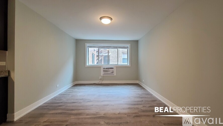 A spacious room with a window and a view of a building outside.