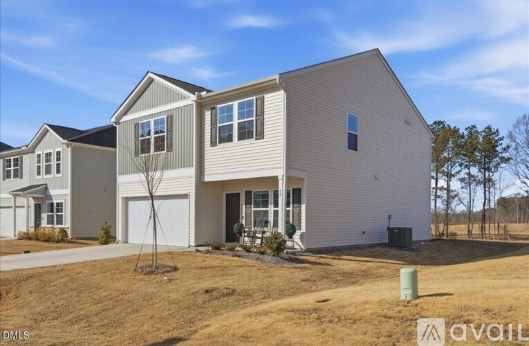 A modern house with a large front yard is for sale.