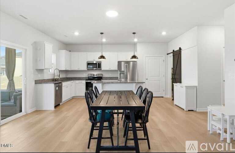 A kitchen with a table and chairs in the middle of the room.