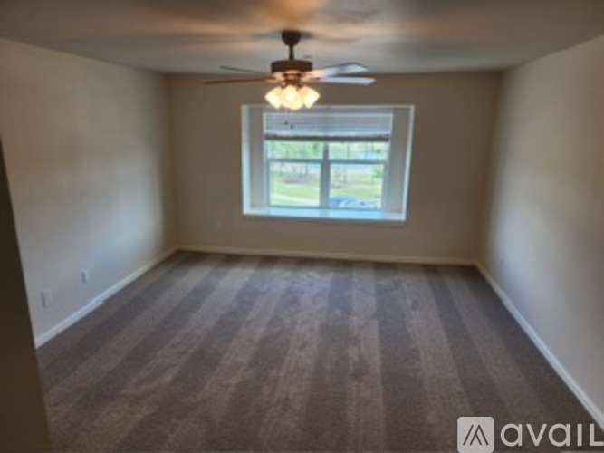 A room with a ceiling fan and a window.