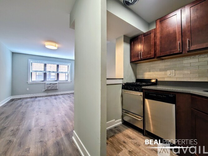 A kitchen with wooden cabinets and a stainless steel dishwasher.