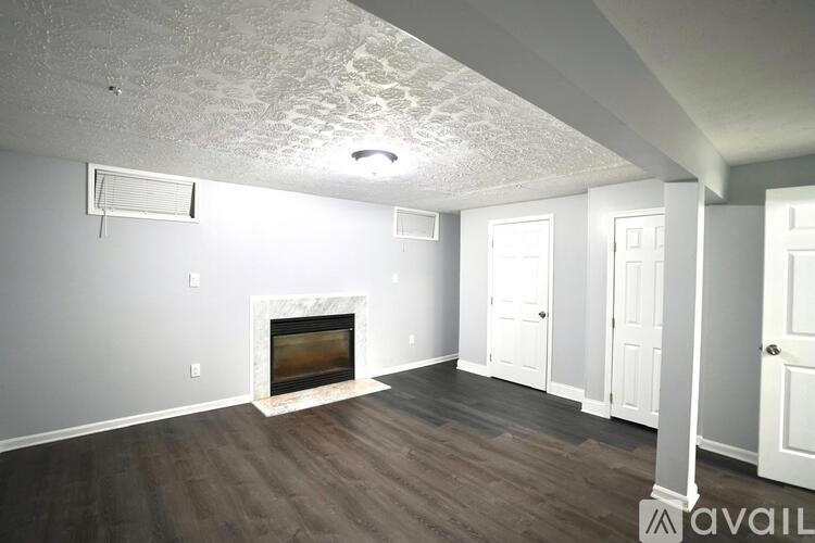 A spacious living room with a fireplace and wood flooring.