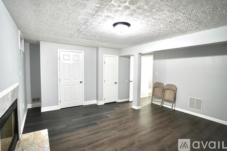 A room with a fireplace and two chairs.