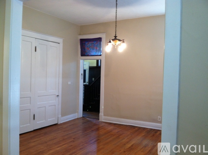A room with a wooden floor and a white door.