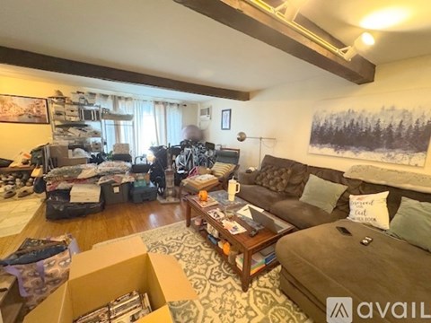 A living room with a couch, coffee table, and a painting on the wall.