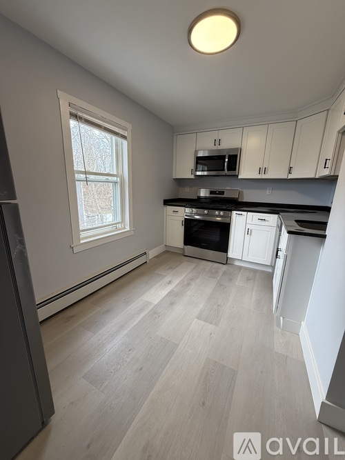 A kitchen with a window and a stove top oven.