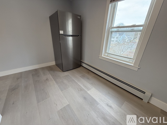 A room with a grey floor and a window showing a snowy landscape outside.