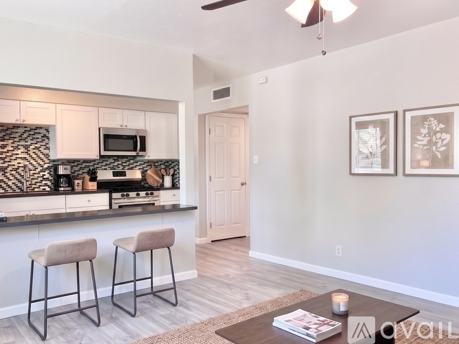 A kitchen with a bar stool and a book on the table.