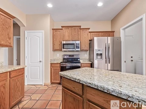 A kitchen with wooden cabinets and granite countertops.
