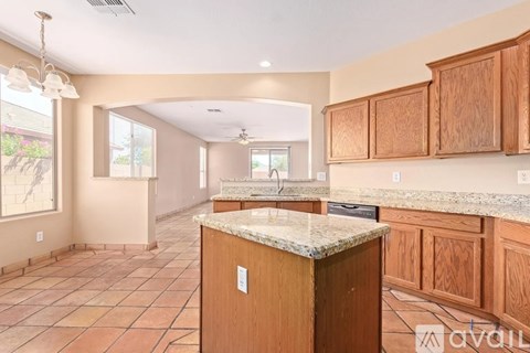 A kitchen with wooden cabinets and a marble countertop.