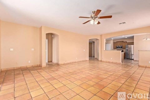A spacious room with a ceiling fan and tile flooring.