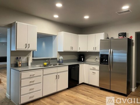A kitchen with white cabinets and a stainless steel refrigerator.