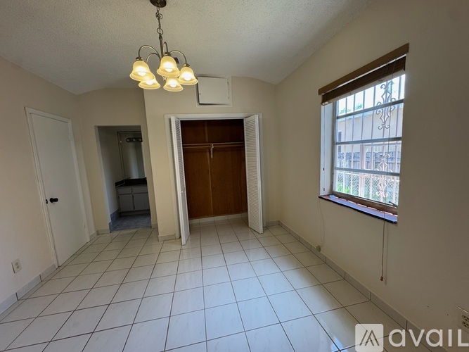 A room with a tiled floor and a chandelier hanging from the ceiling.