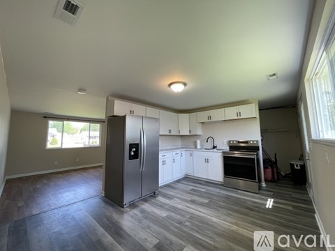 A kitchen with a refrigerator, oven, and cabinets.