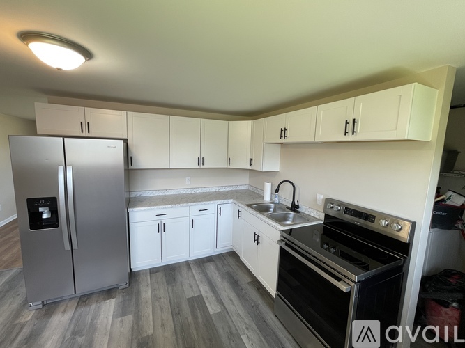 A kitchen with a refrigerator, oven, and cabinets.