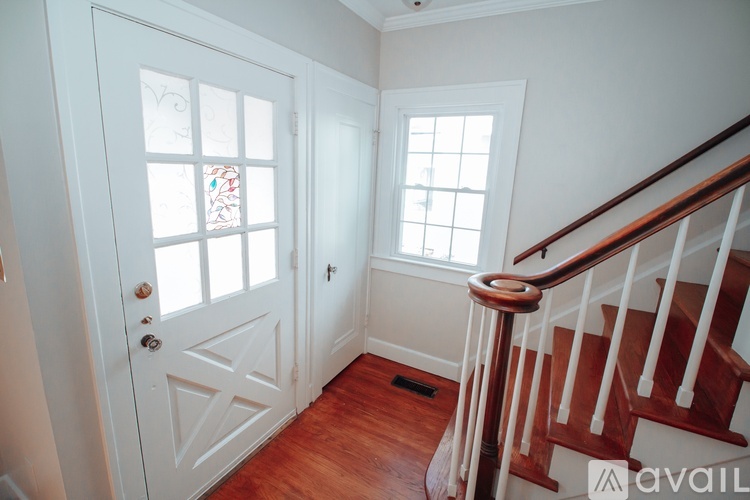 A white door with a glass window and a wooden staircase.