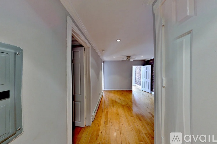 A long hallway with wooden floors and white walls.