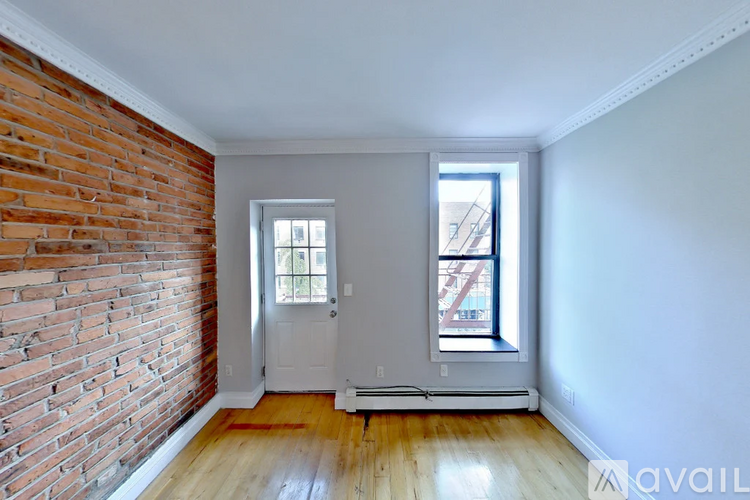 A room with a brick wall and a white door.