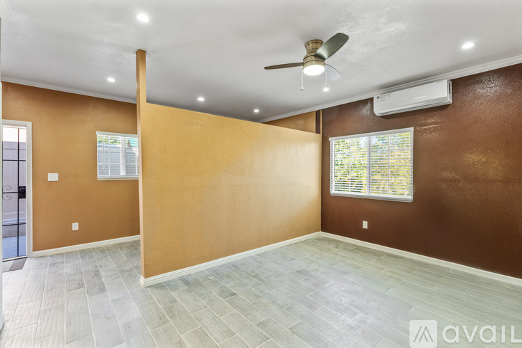 A room with a ceiling fan and a window with blinds.