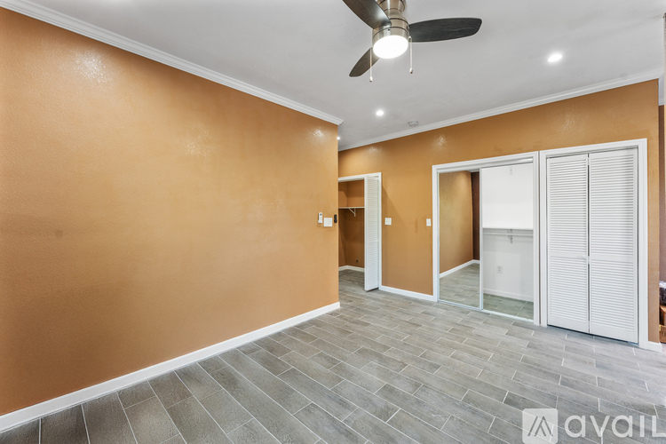 A room with a ceiling fan and sliding doors.