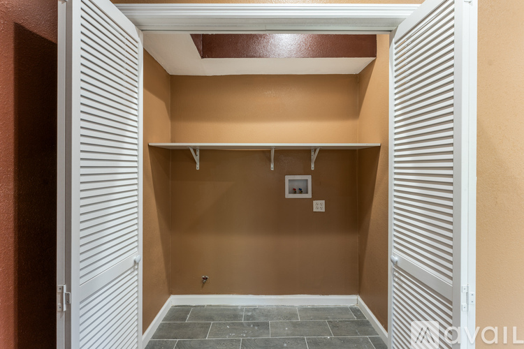 A white closet with a brown wall and a white door.