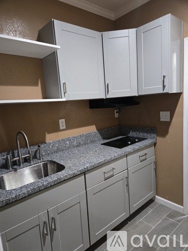 A kitchen with white cabinets and a granite countertop.