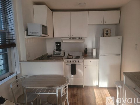A kitchen with white appliances and a table.
