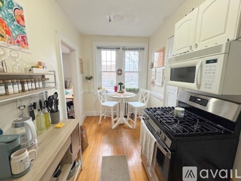A kitchen with a black stove top oven and white cabinets.