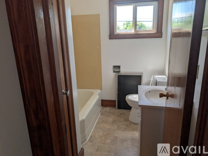 A bathroom with a tub, toilet, and sink.