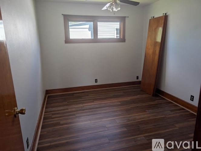 A room with wooden flooring and a ceiling fan.