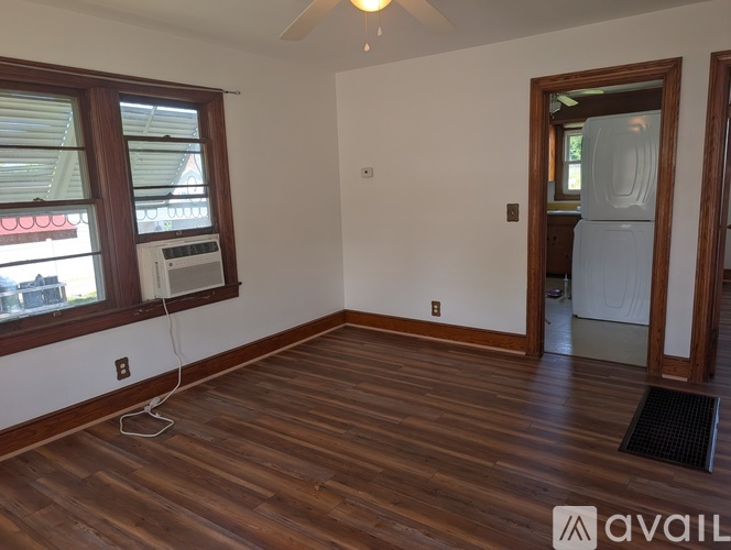 A room with wooden flooring and a window with blinds.