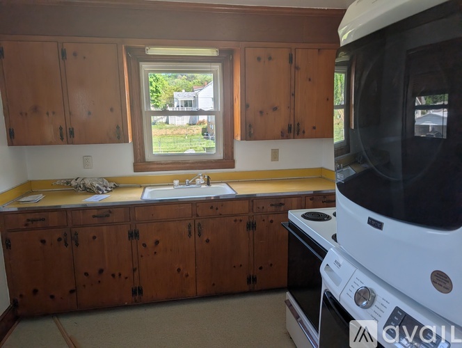 A kitchen with wooden cabinets and a window.