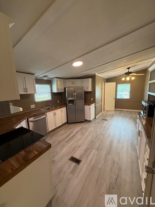 A kitchen with wooden floors and a black countertop.