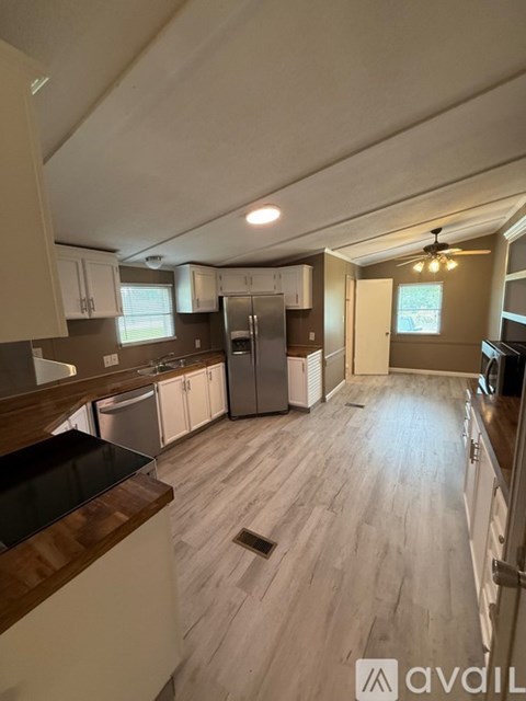 A kitchen with wooden floors and a black countertop.