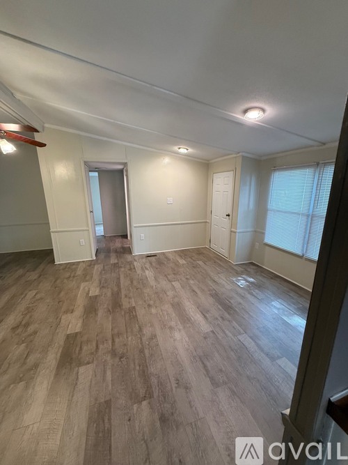 A room with wooden flooring and white walls.