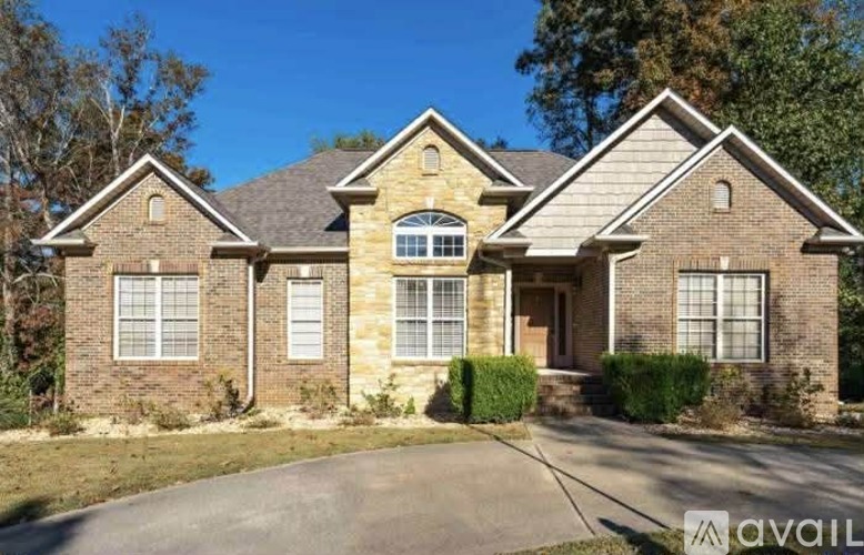 A house with a brown brick exterior and a large front yard.