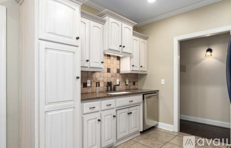 A kitchen with white cabinets and a tile backsplash.