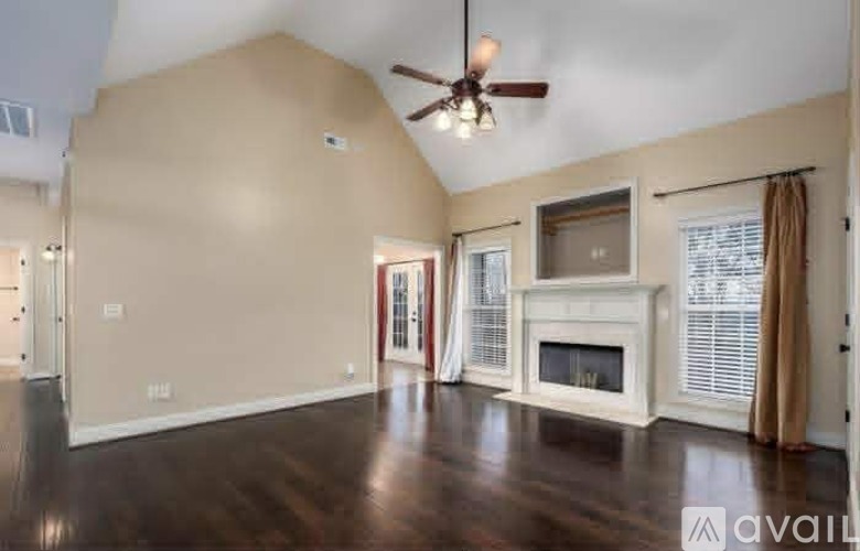 A living room with a fireplace and a ceiling fan.