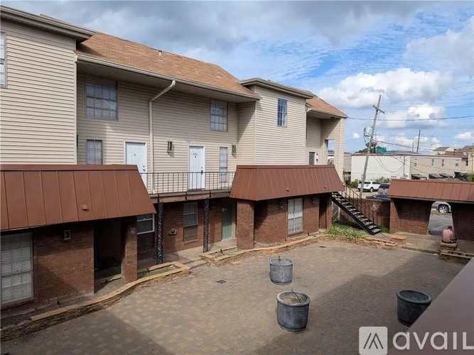 Apartment complex with a brown roof and a cloudy sky.