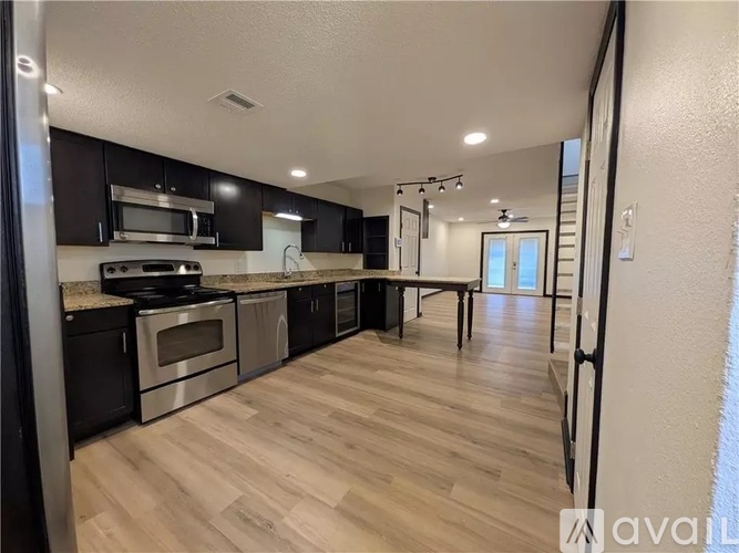 A kitchen with black cabinets and stainless steel appliances.