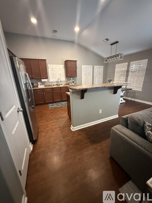 A kitchen with wooden floors and a white refrigerator.