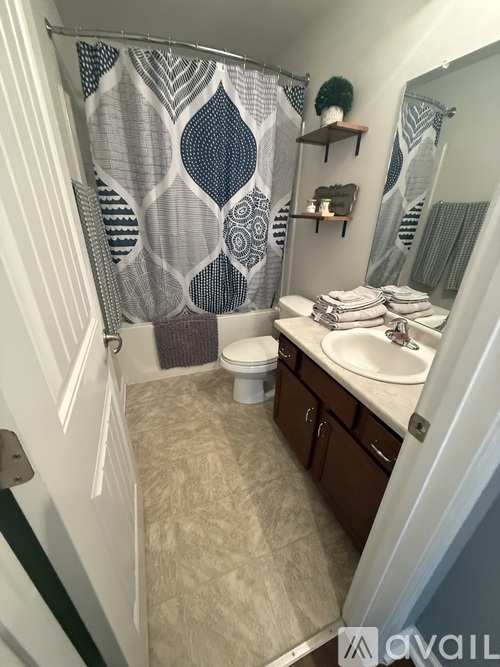 A bathroom with a shower curtain and a toilet.