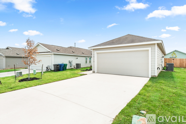 A house with a garage and a driveway in front of it.