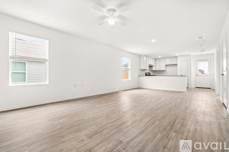 A spacious room with wooden flooring and a ceiling fan.