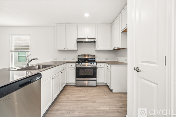 A kitchen with white cabinets and a stainless steel dishwasher.