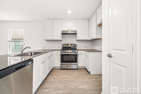A kitchen with white cabinets and a stainless steel dishwasher.