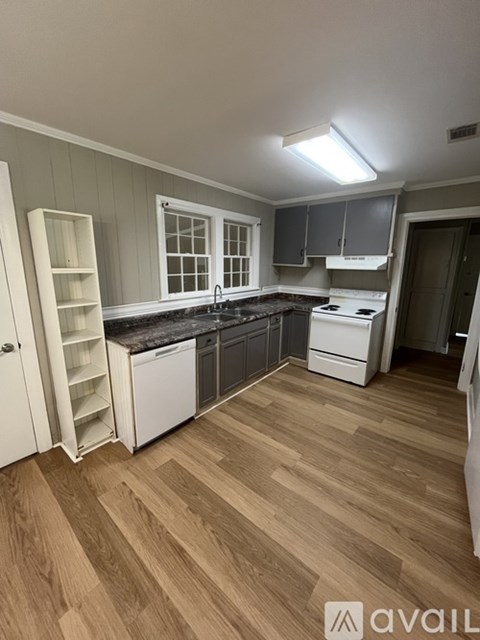 A kitchen with wooden floors and white appliances.