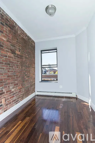 A room with a brick wall and wooden flooring.