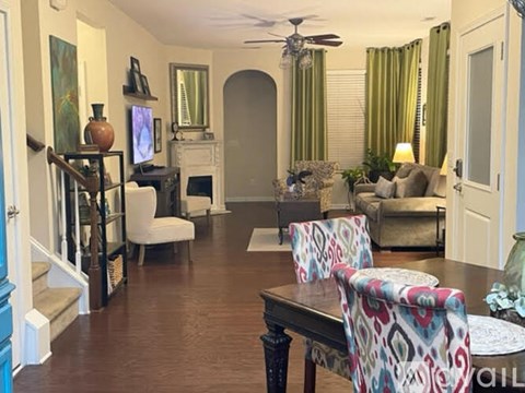 A living room with a white chair and a patterned cushion.